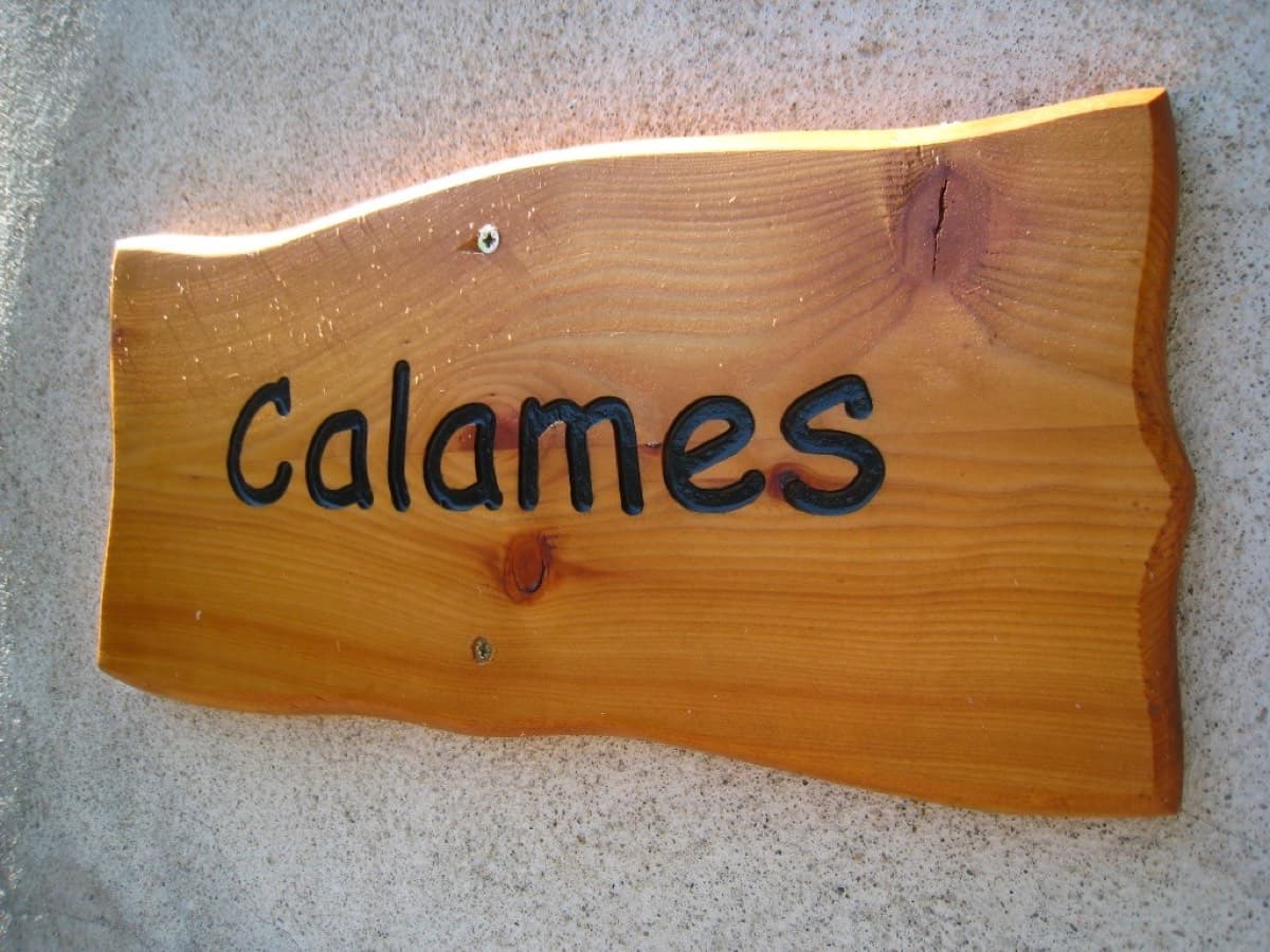 The wooden "Calames" sign in the village of Bédeilhac, which confirms you are on the right path to the crag.