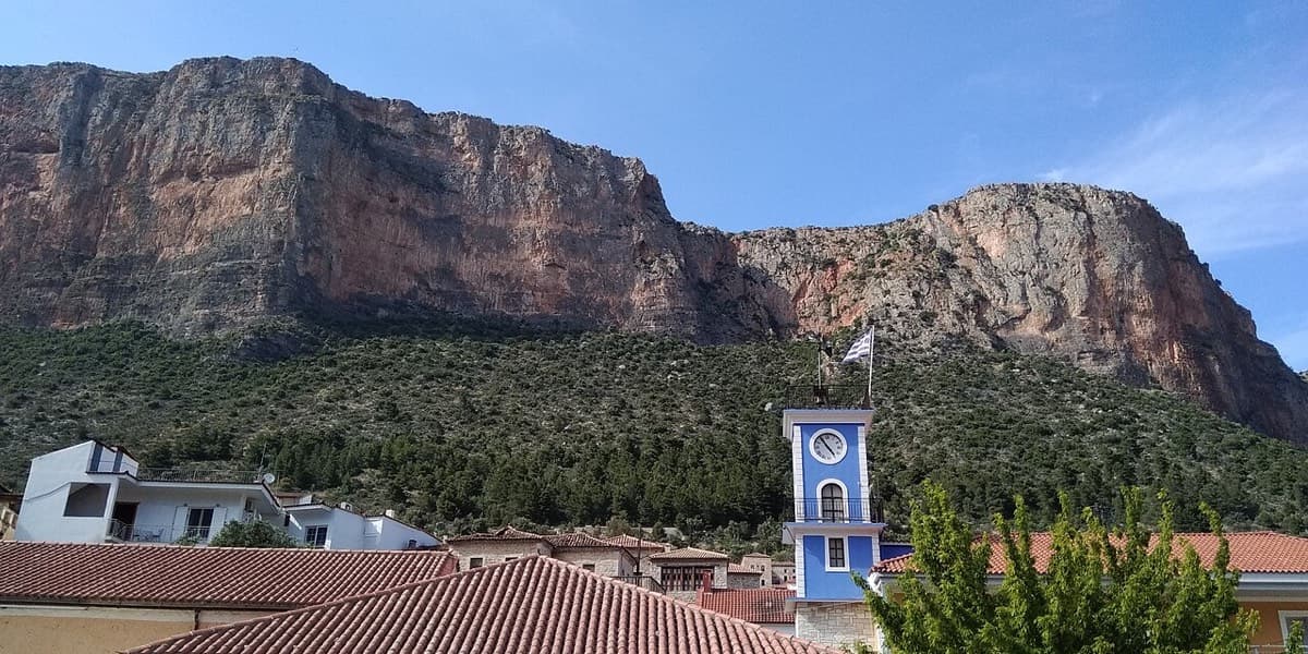 Kokkinovrachos seen from the centre of Leonidio, above the blue clock tower of the town hall: the wall you walk up to from the village.