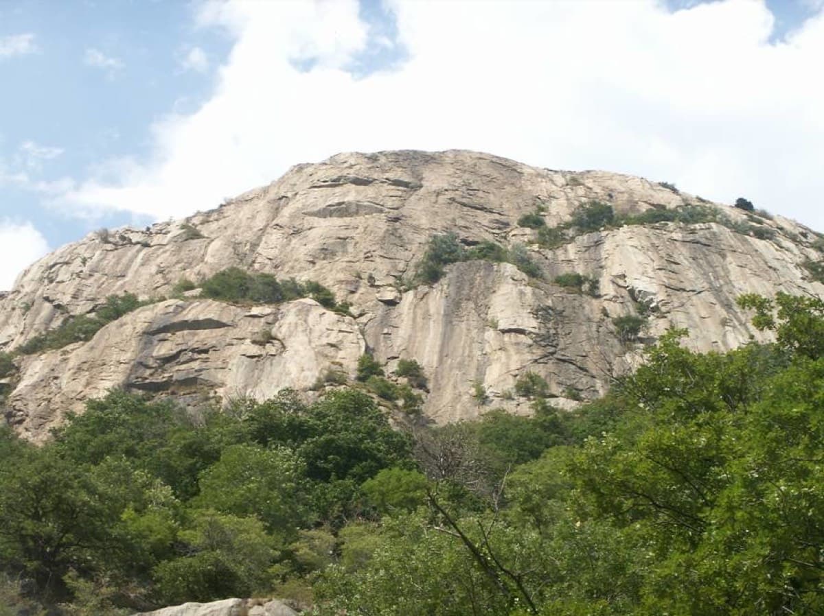 The Paretone di Arnad seen from below, through the trees at its foot.