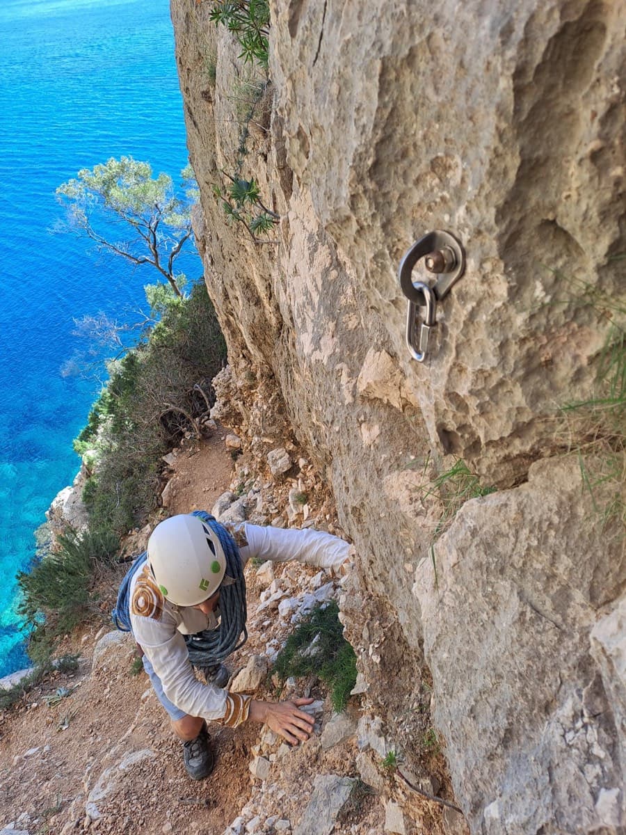 The wrong abseil point on the approach ledge: a single bolt with a maillon. The photographer's warning is not to use it; continue to the chained station.
