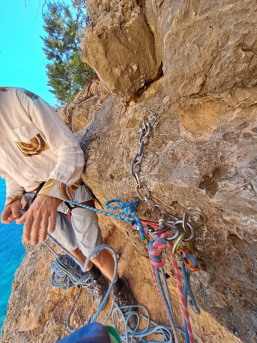 The correct approach abseil: a stainless station with a chain, from which one abseil of about 20 m reaches the rocky beach.