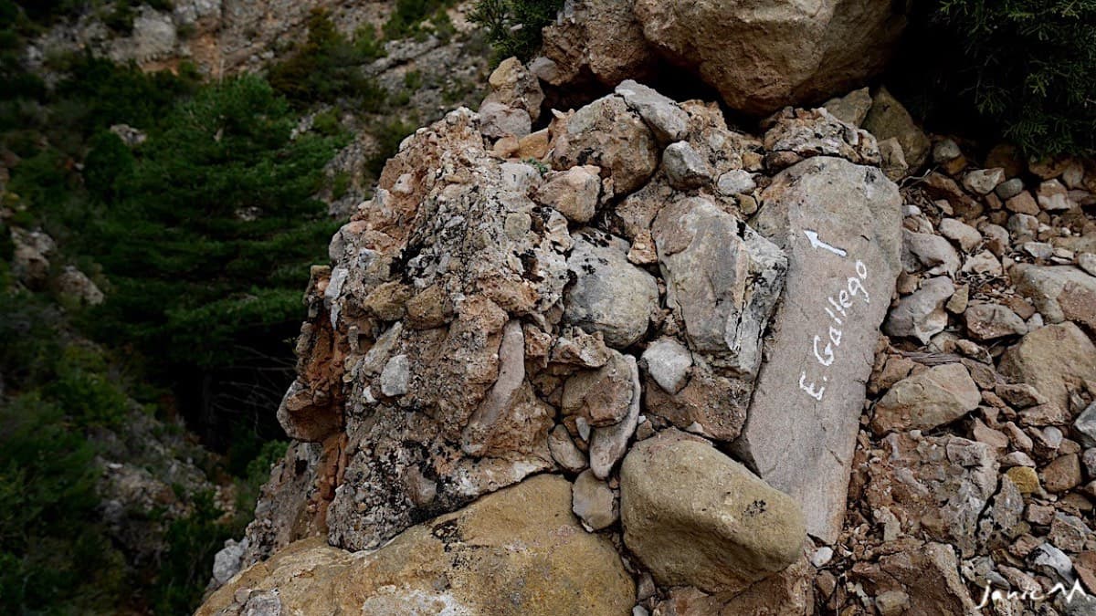 The "E. Gallego" arrow painted on a boulder just before the gully: follow it rather than turning up left too early.