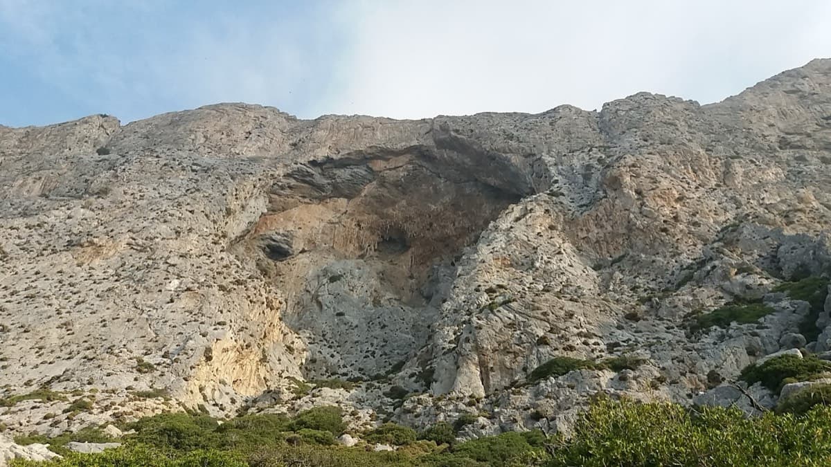 The Crescendo cave on the south face of Telendos, seen from below. Eterna starts a little left of the cave, where the cliff forms a fold, just right of Wild Country.