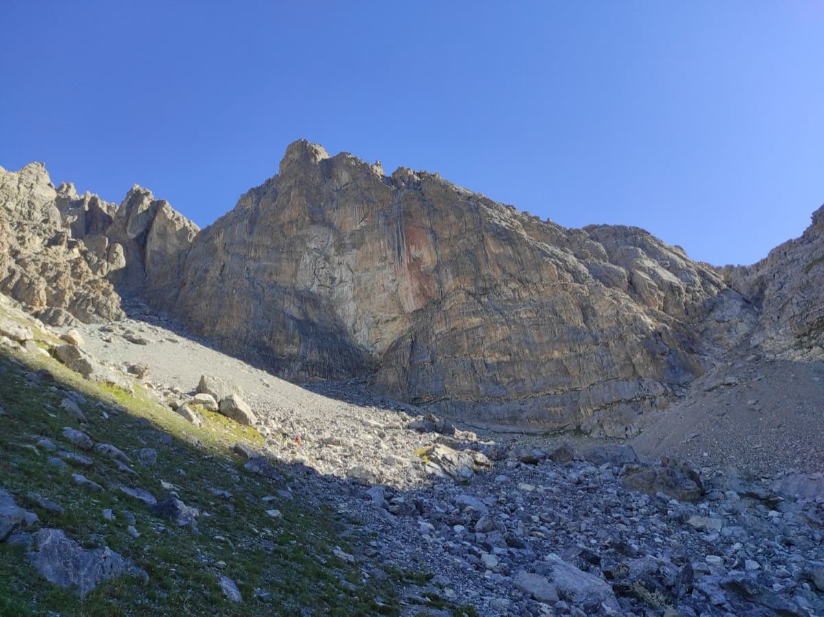 The face of the Tour Termier from the combe on the walk-in; the approach climbs the scree to its foot (August 2025).