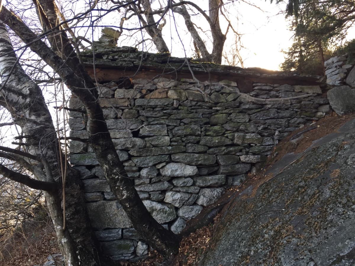 The stone ruin you traverse to on the walk-off, following white dots and cairns above the top of the route.