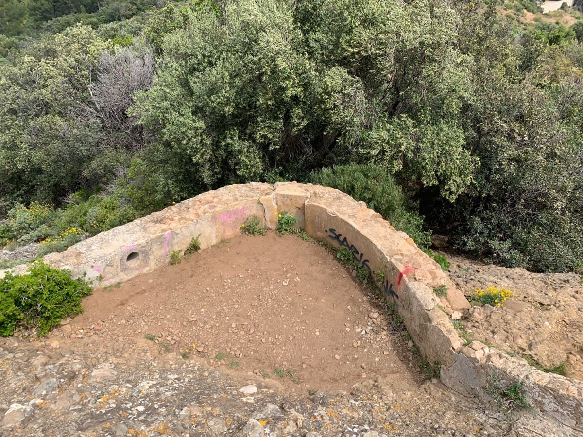 The low wall at the foot of the impluvium: from here go down into the vegetation below (red marks).