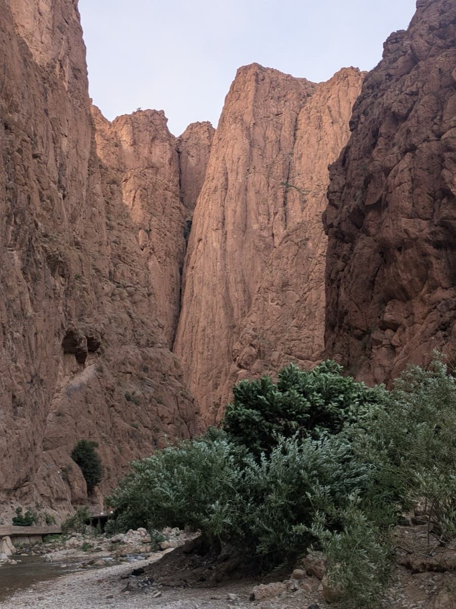 The Pilier du Couchant seen from the gorge entrance: the tall pillar in the centre, reached by crossing the stream.