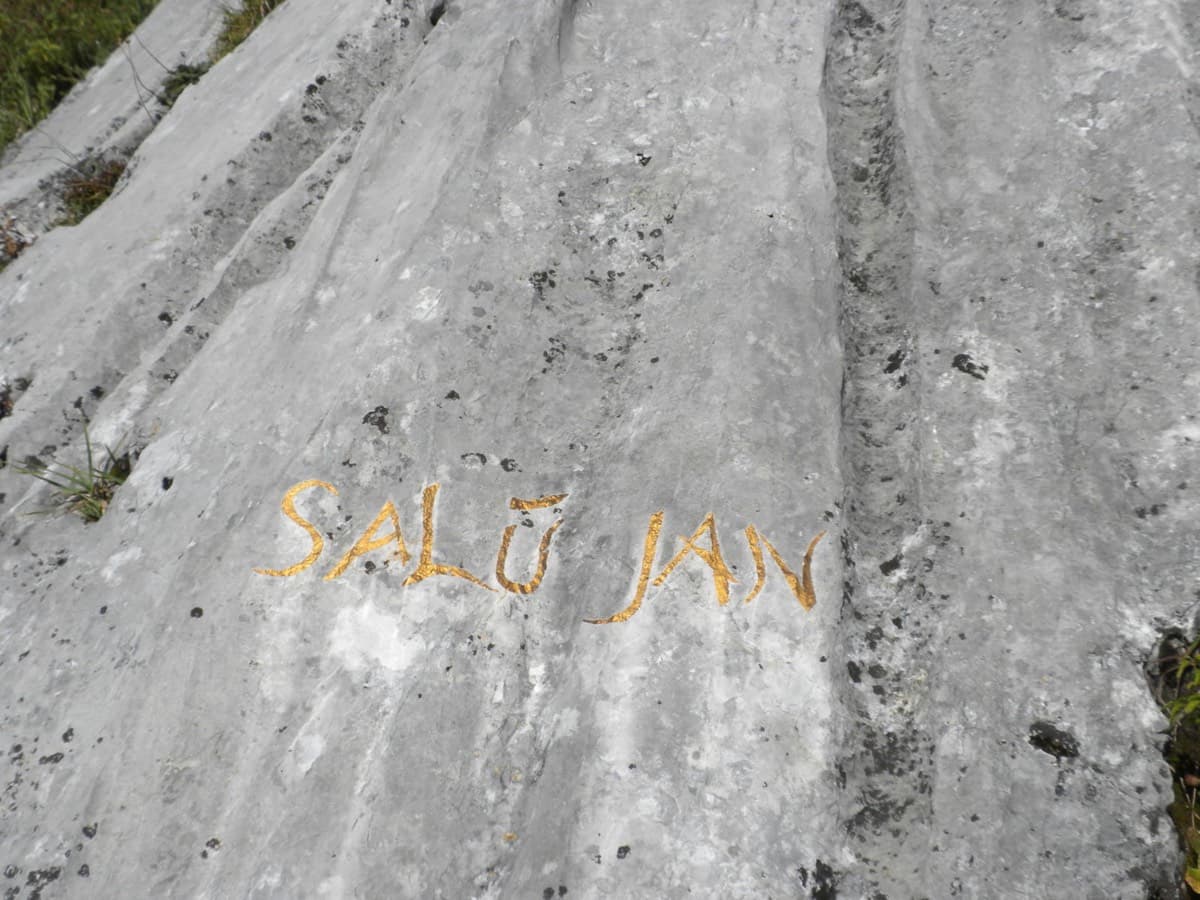 The route name 'SALÜ JAN' painted in yellow on the slab at the start.