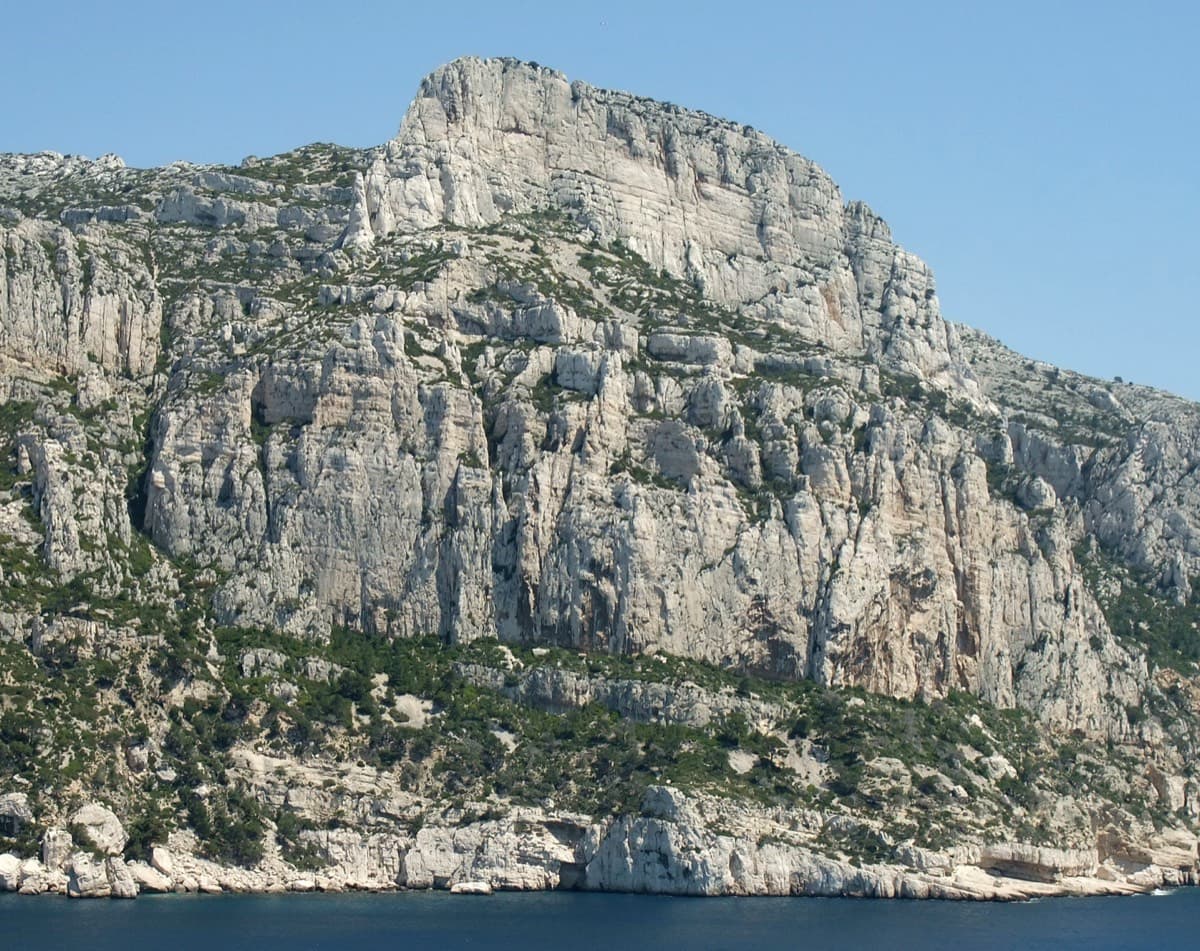 The Grande Candelle and its plinth from the sea; Armata Calanca climbs the plinth and then the south face to the summit