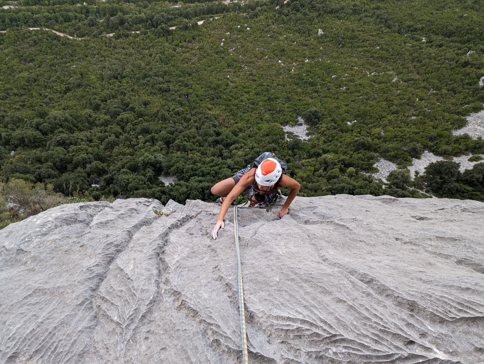 Looking down the sculpted grey limestone above the overhang of pitch 6 of Alfredo Alfredo, with the Oddoene valley below.