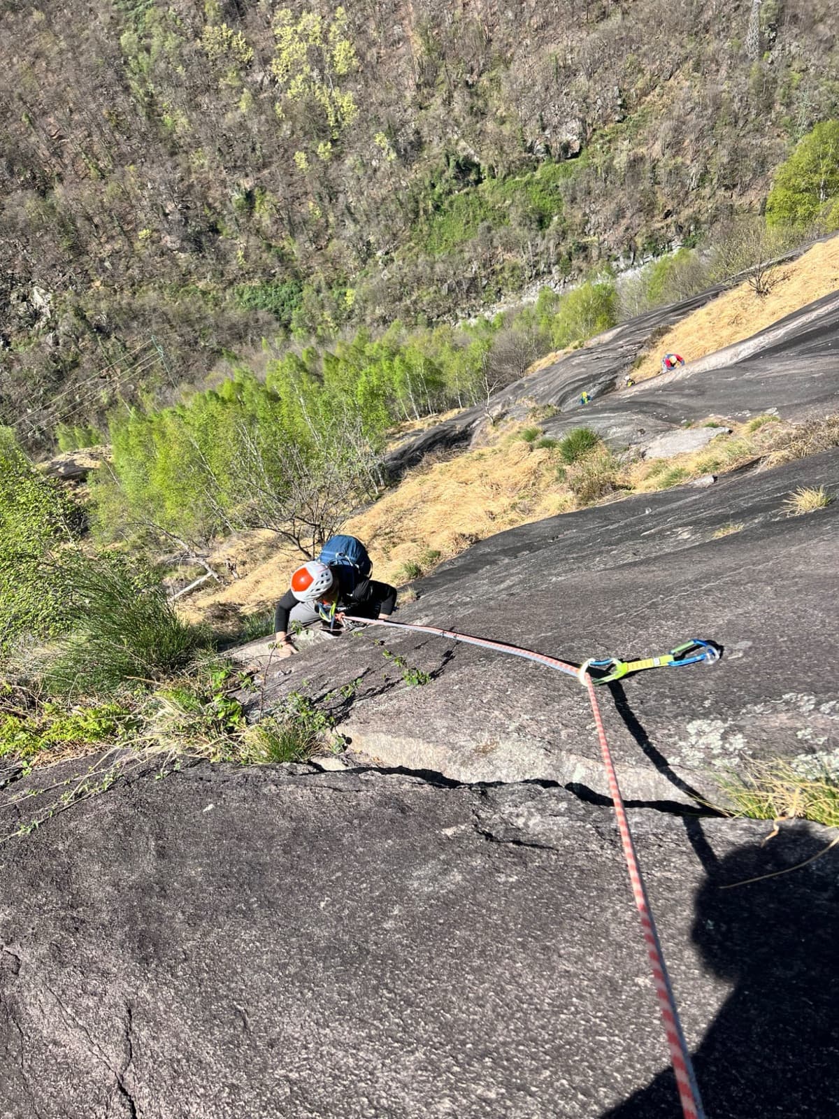 A view of the region, not this route's wall. Looking down the dark gneiss slabs of Il Solitaire above the Val d'Ossola.