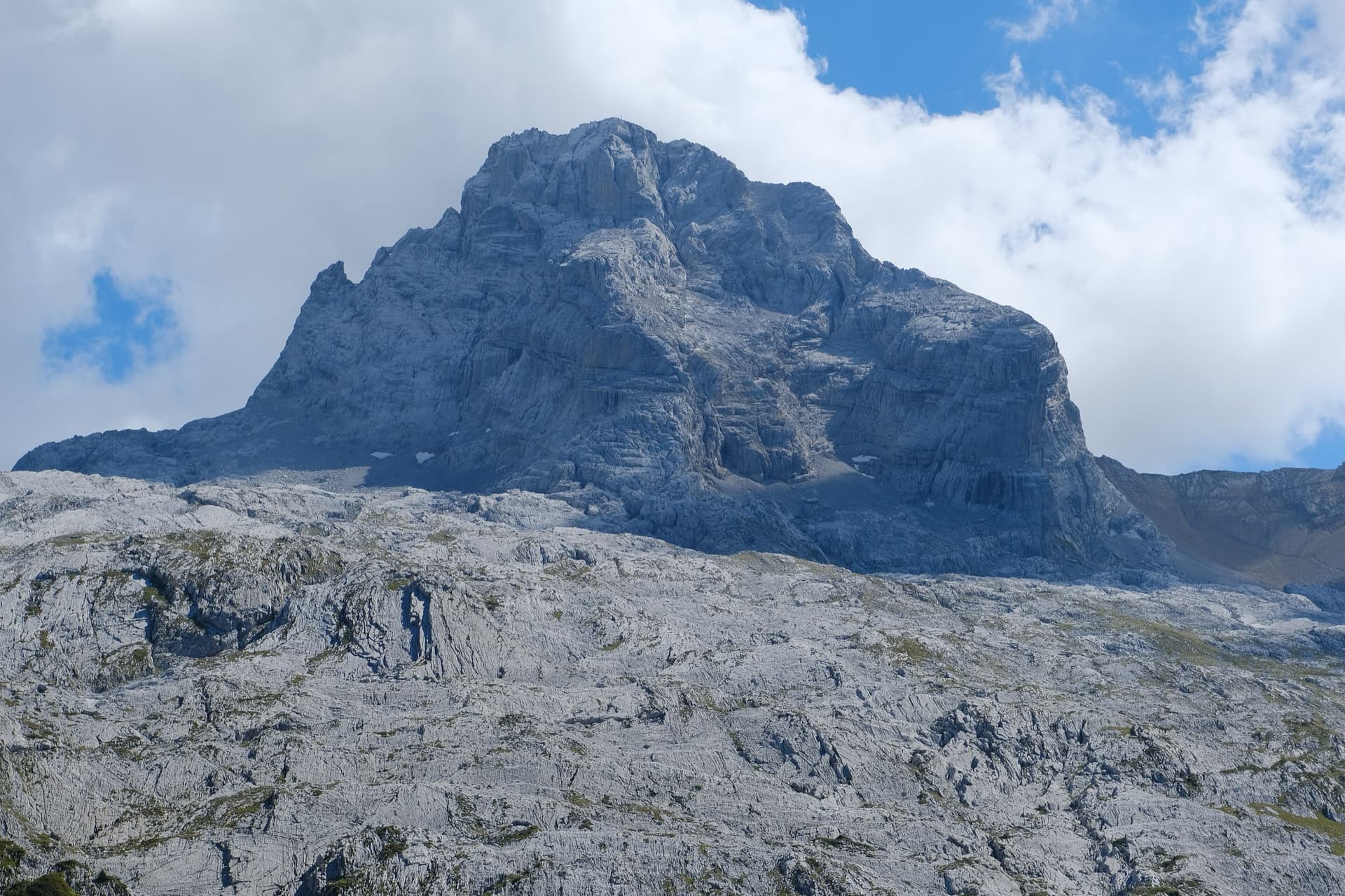 The Pointe Percée above the limestone pavement of the Gramusset plateau, seen from the north-west; Le sirop pour machin starts from the crags near the hut and finishes on the summit, the exact line is not marked.