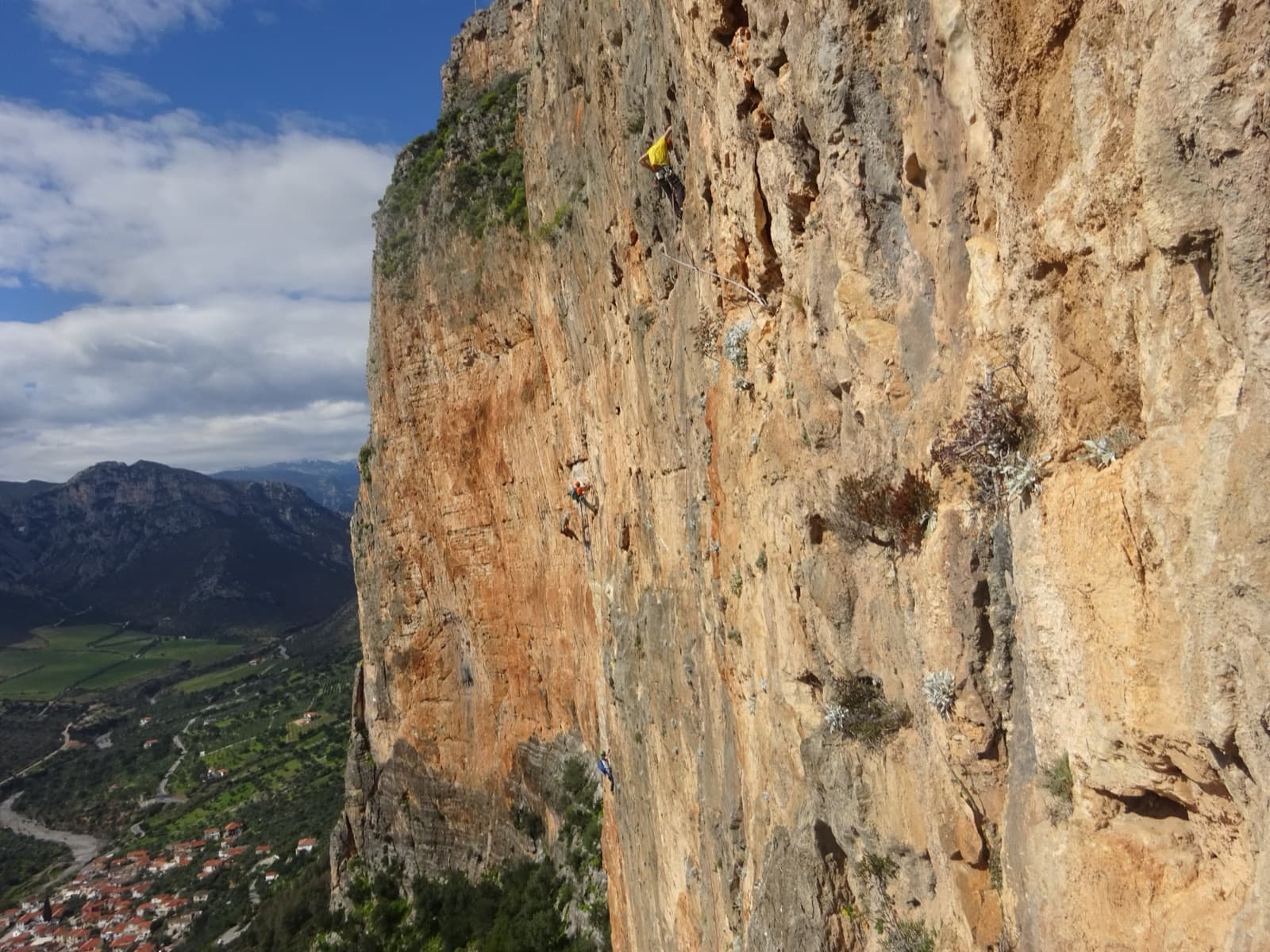 Climbers on the neighbouring lines of the Kokkinovrachos wall, with Leonidio below.