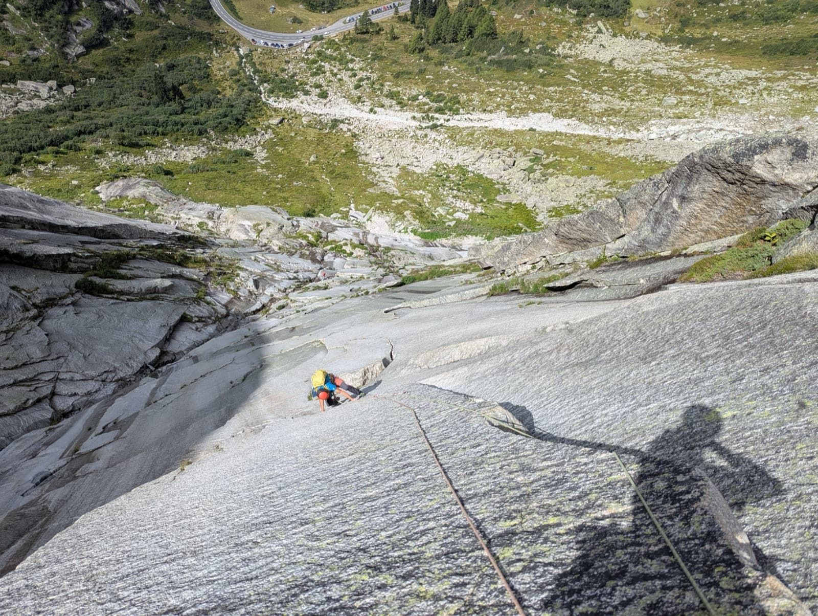 Slab climbing on pitch 6 of Savoir Vivre, the Grimsel road far below.