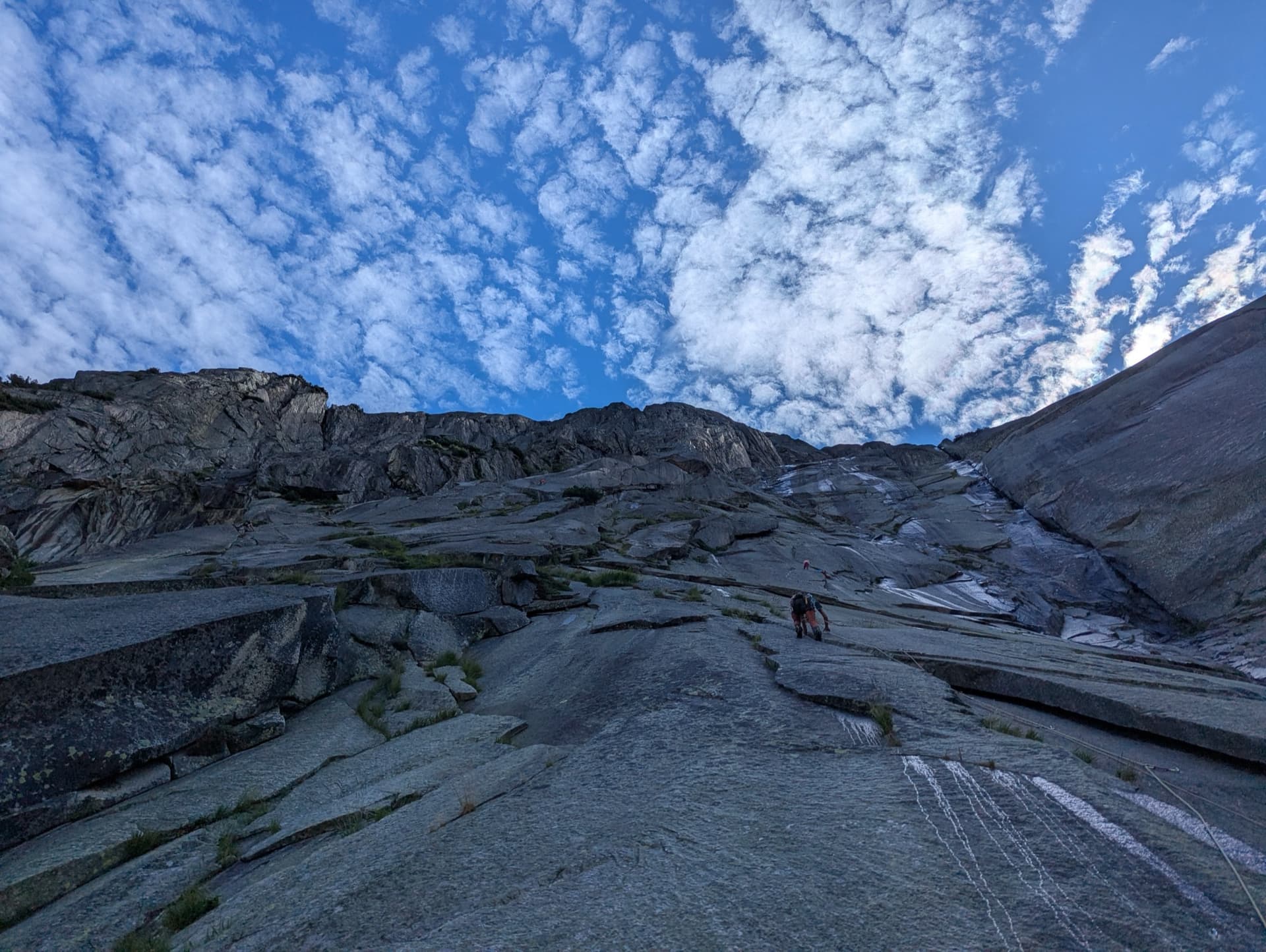 Pitch 3 of Savoir Vivre on the Gelmerfluh, with the slabs of the upper wall under a mackerel sky.