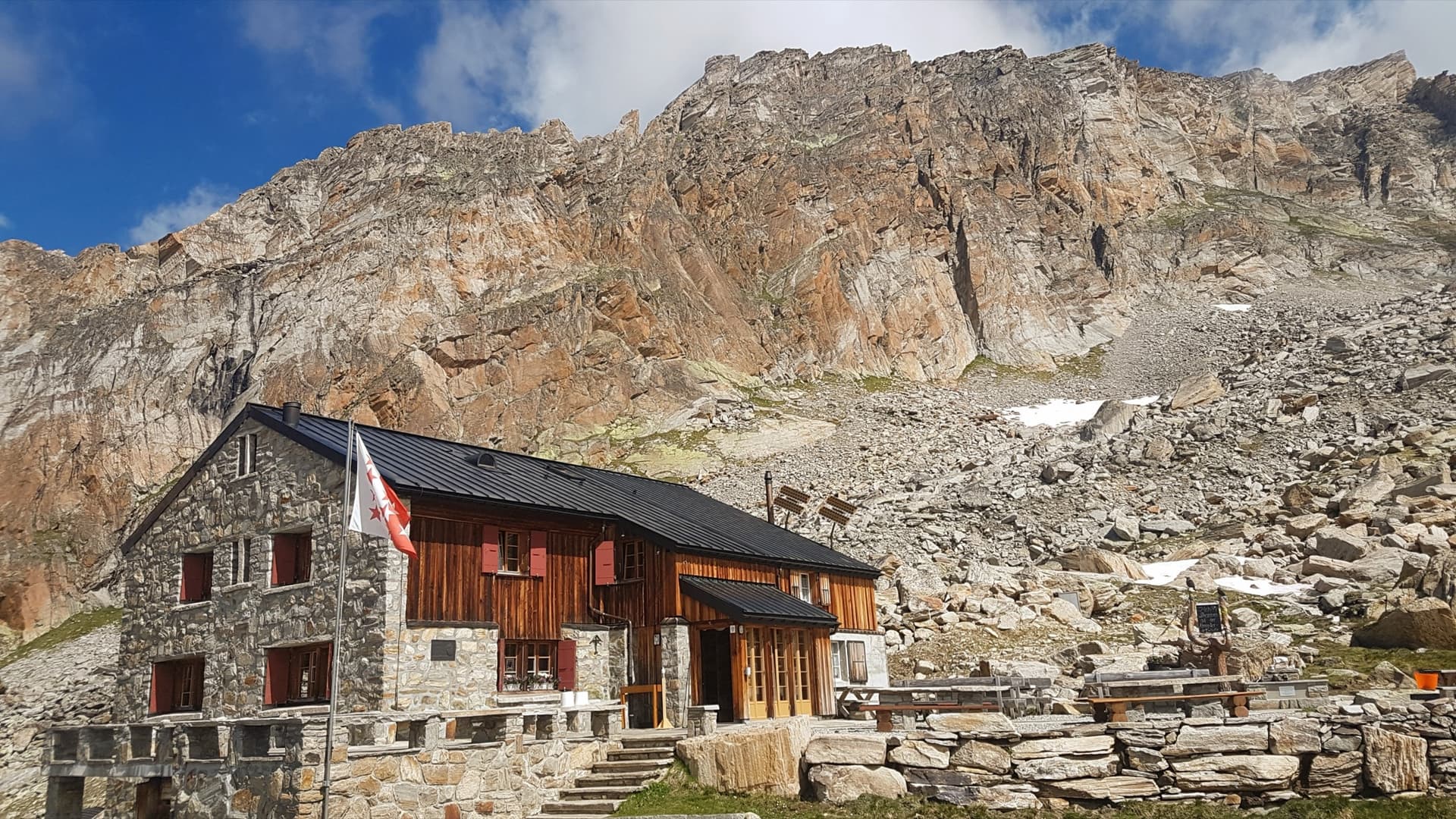 A view of the region, not this route's wall. The Almagellerhütte with the orange gneiss walls of the Dri Horlini rising directly behind it.