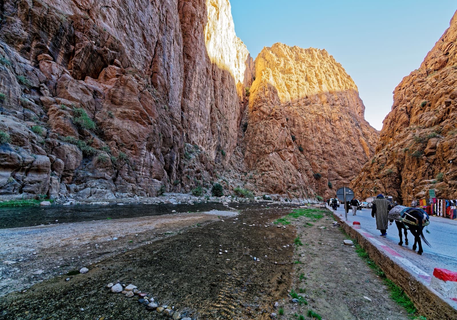 The narrows of the Todra Gorge in late afternoon light, with the river and the road on the canyon floor; a general view of the gorge, not of this route's wall.