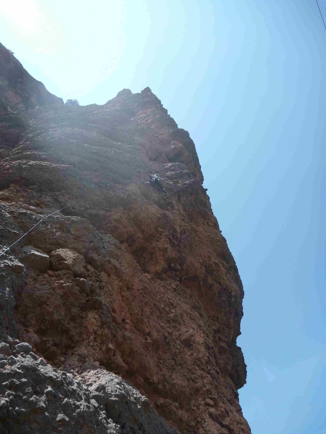 Looking up the first pitch of Matute on the Agulla del Gos, Collegats, with a climber high on the pinnacle