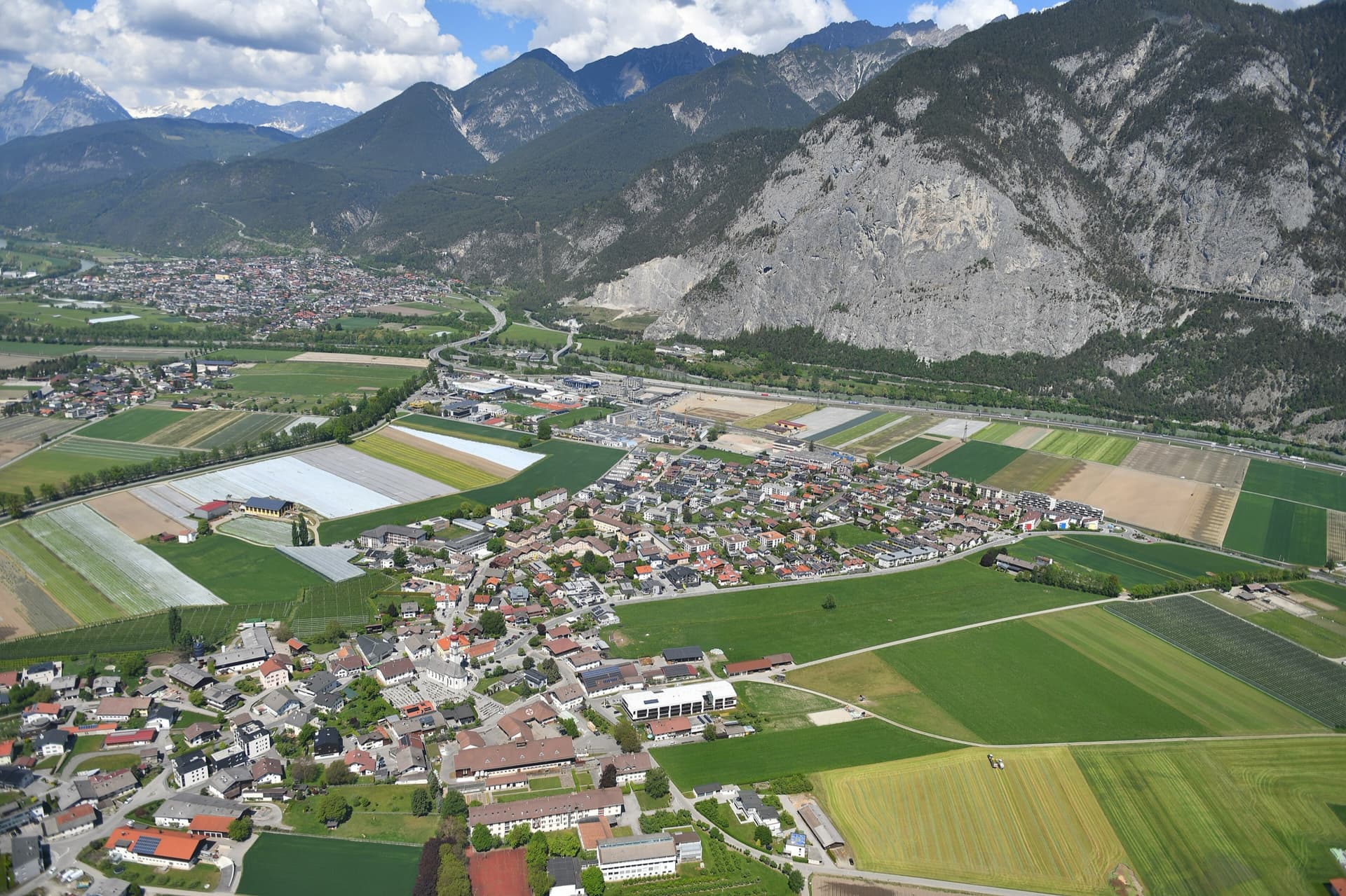 Aerial view over Kematen to the south face of the Martinswand, with Zirl on the left. The Vorbau routes are on the lower slabs at the right-hand (eastern) end of the wall; the line is not marked.