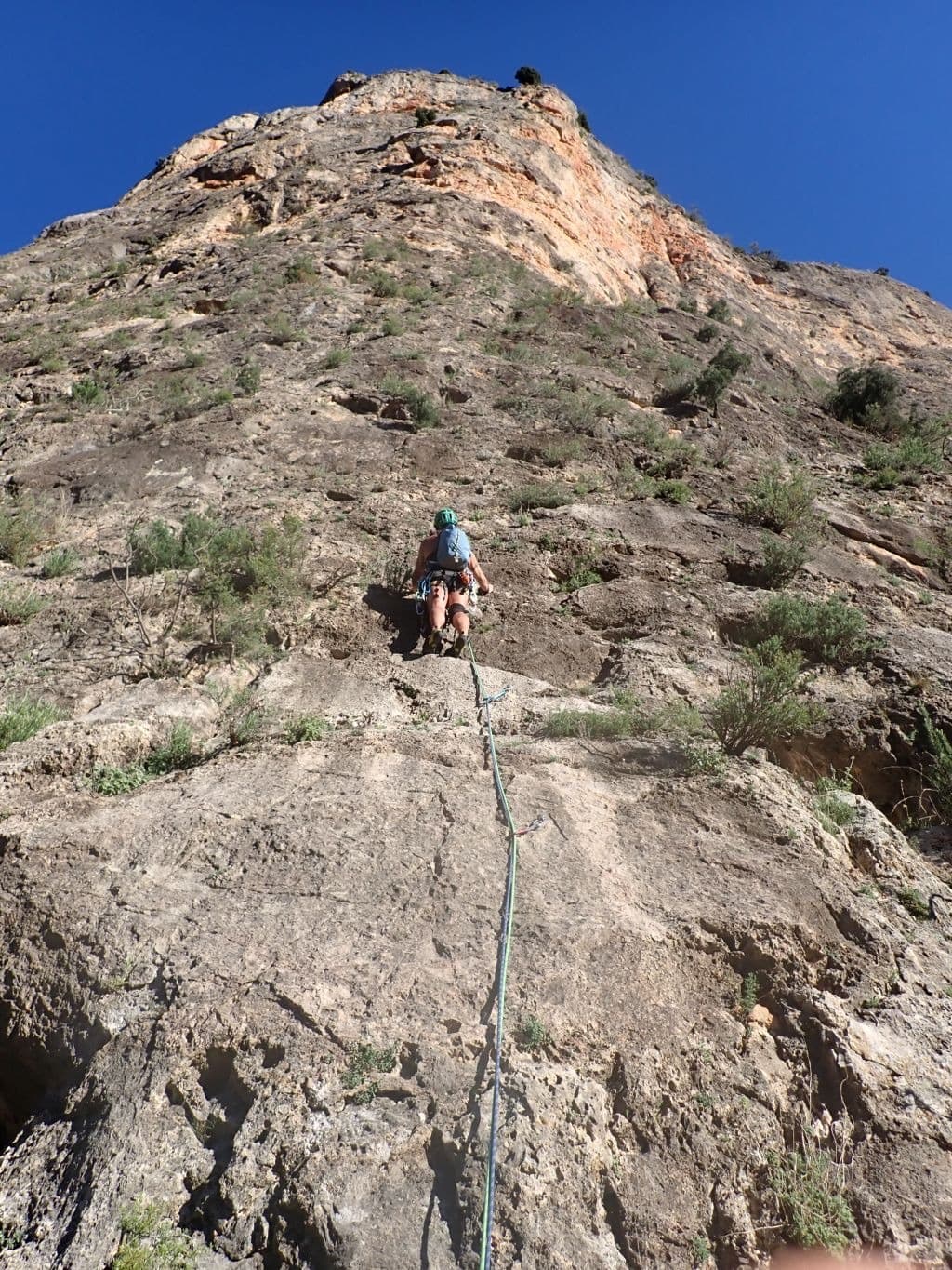 The Paredón del Alguacil from the first pitch of the neighbouring route Pitufosis. Radio Patio climbs the orange upper wall; its line is not marked.