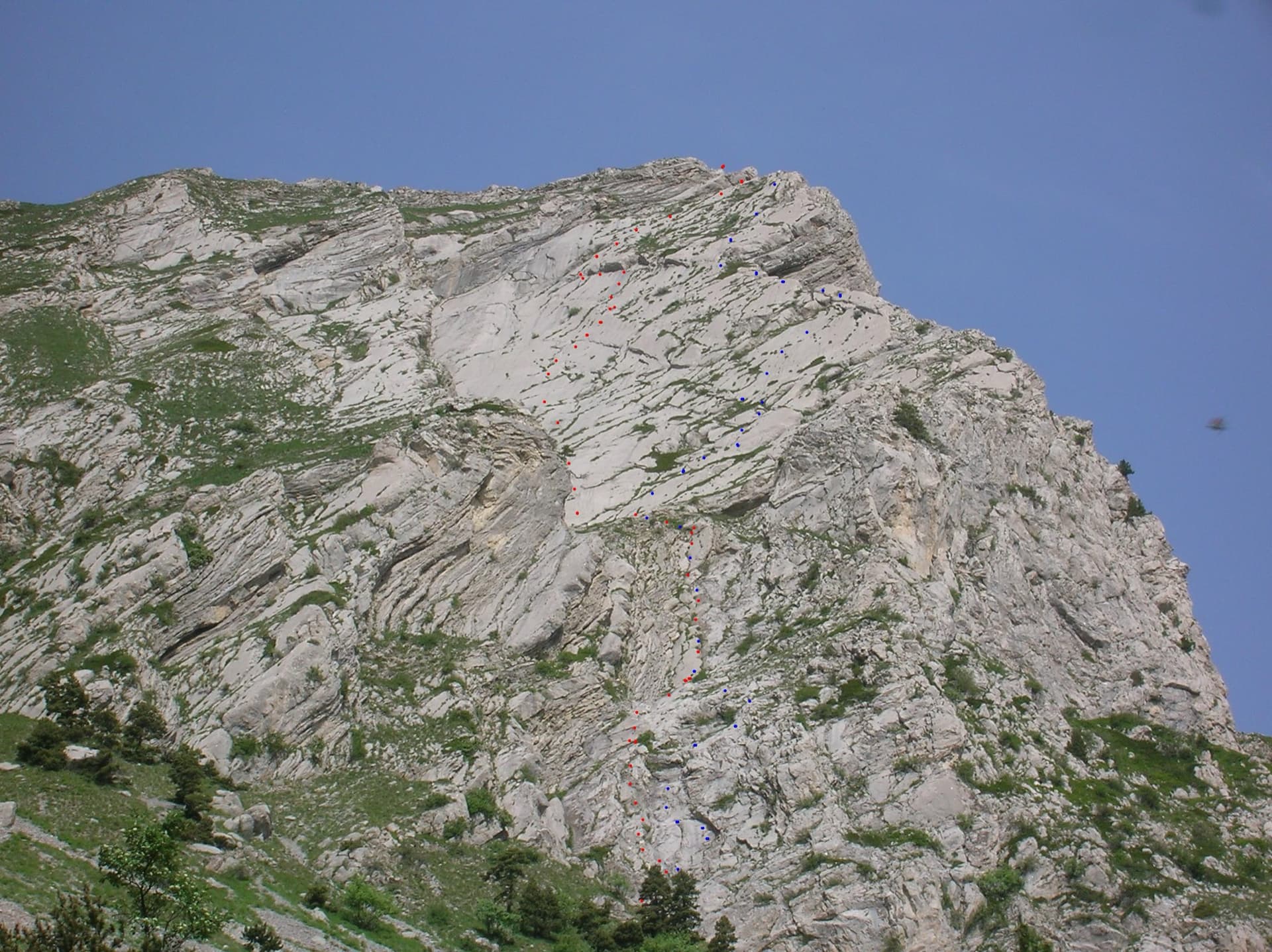 The east face of the Pic de l'Aiguille with two dotted route lines drawn by Serge Luby, one of the equippers. Camptocamp attaches the picture to both À l'aise Gleize and La Barule des Barulots without saying which colour is which.