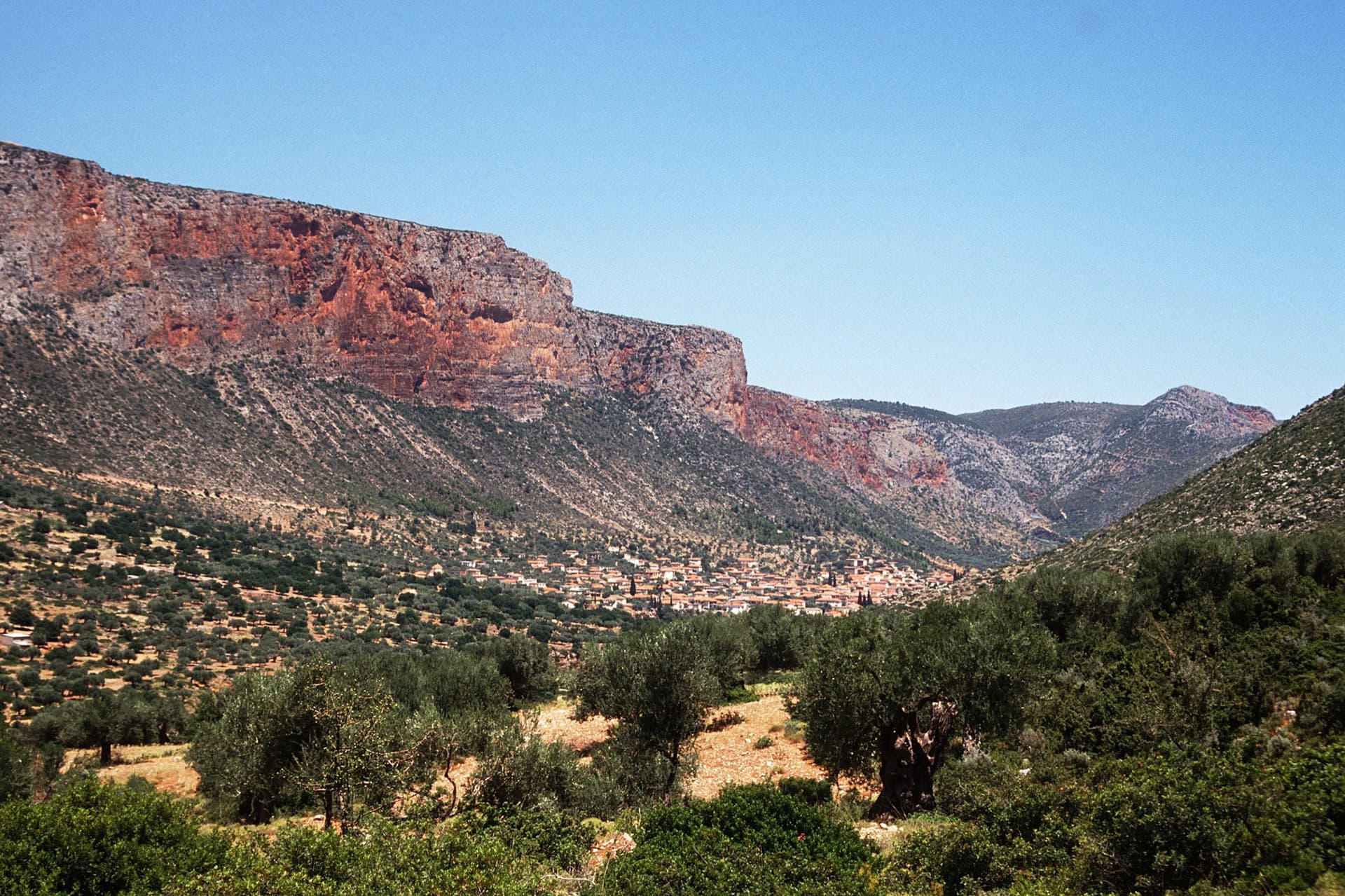 Kokkinovrachos above Leonidio seen from the west; the big sport multi-pitches climb the red wall above the town