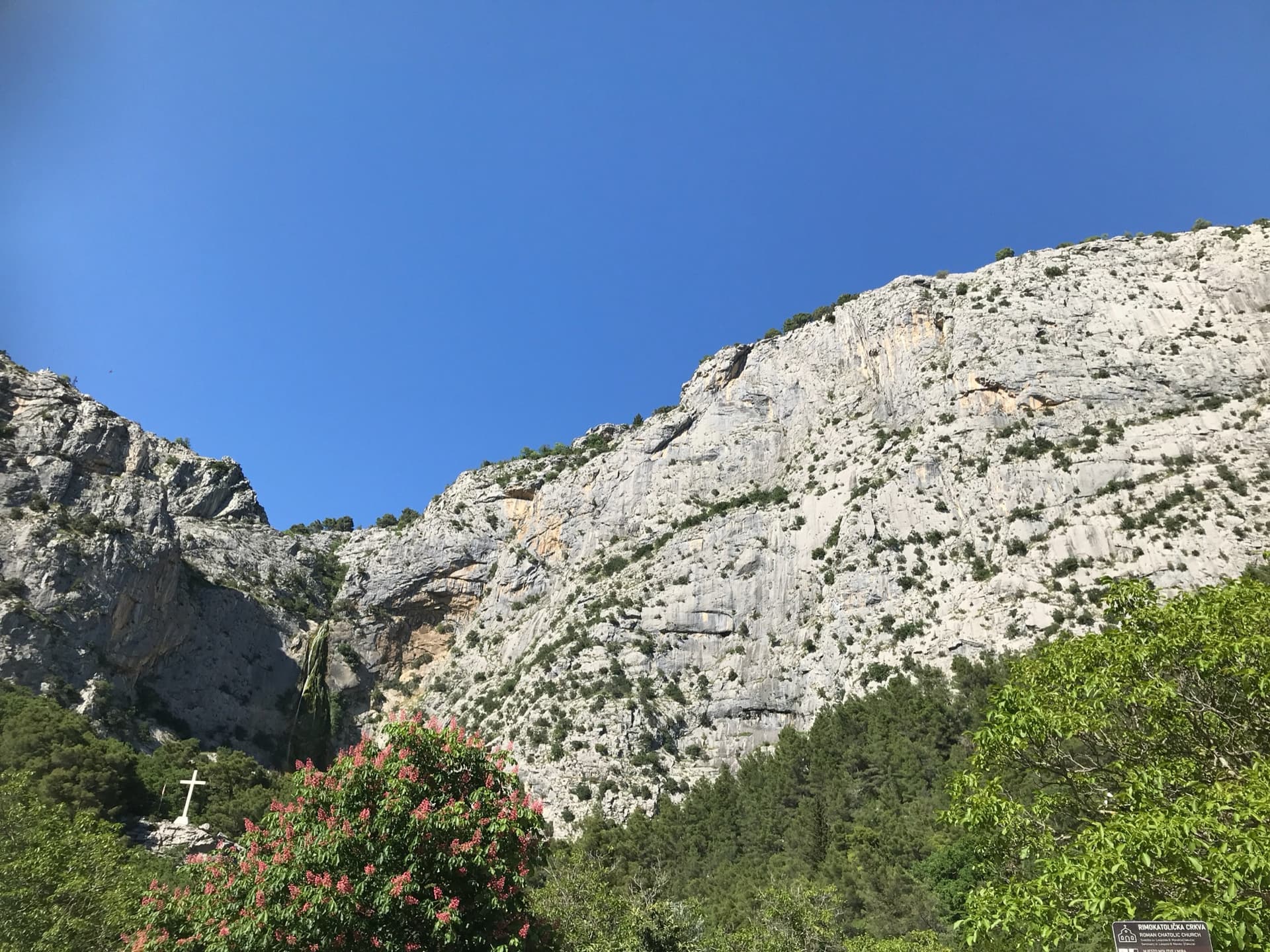 The Ilinac cliffs above Zakučac, seen from the car park; Warthogrock climbs a small tower below the main face and is not marked.