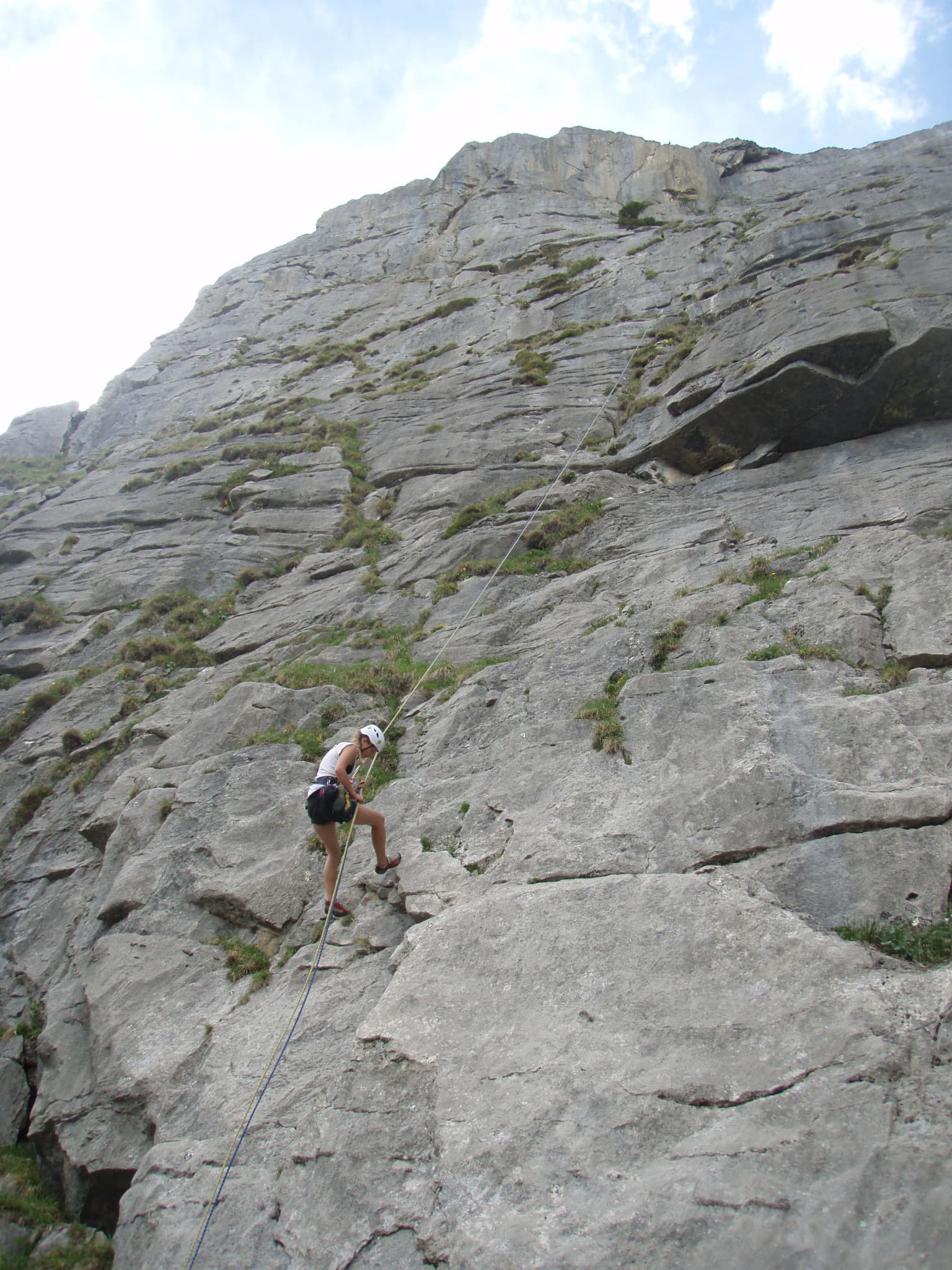 The face of Salü Res at Ueschenen, with a climber on the lower slabs