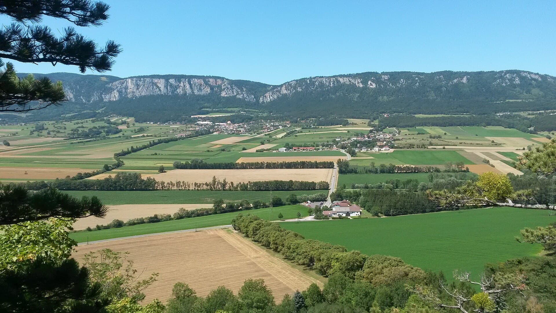 The limestone escarpment of the Hohe Wand above the fields of the Neue Welt basin, seen from the ruins of Burg Emmerberg.