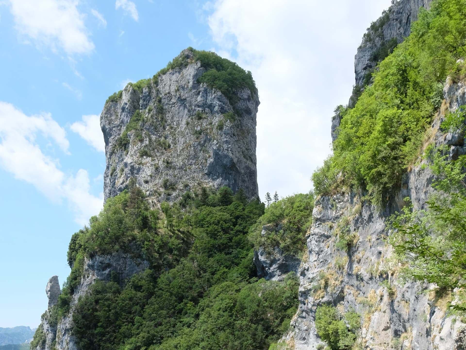The walls of Monte Procinto rising above the ledge path, seen from path 5 on the approach.