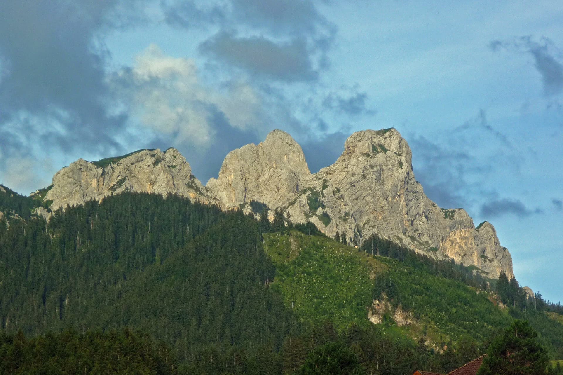 The Schartschrofen, Gimpel and Rote Flüh from Grän on an August evening, the limestone summits of the Tannheim mountains lit by the last sun.